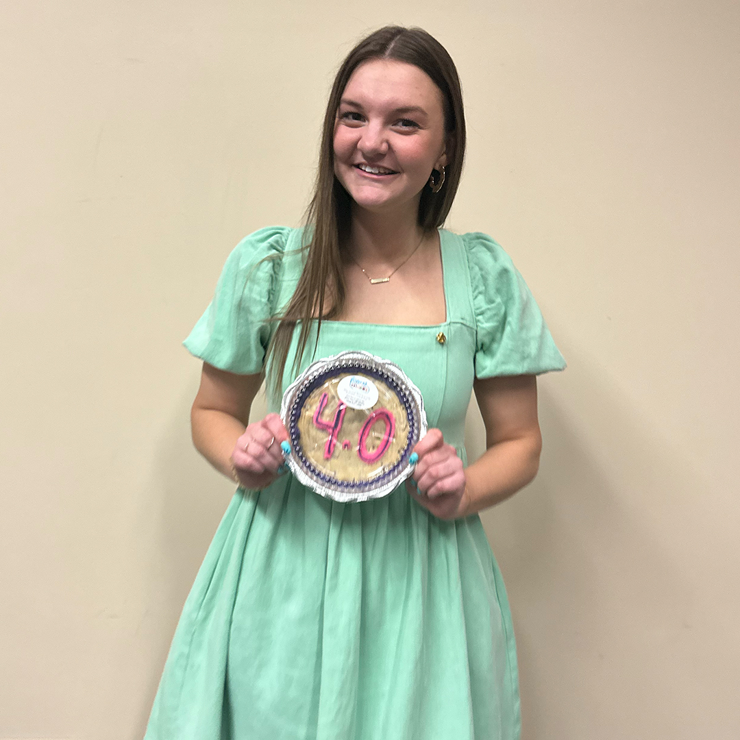 Travi Tighe posing with her 4.0 cookie.