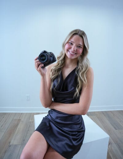 Vice President of Marketing Kaylee Mustion poses with her camera.