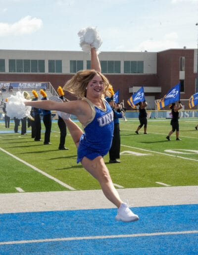 Hadyn Ferguson does a starbird jump during a football game.