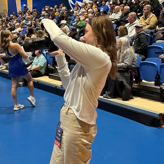 IMG_1902 2 Travi Tighe in front of media day backdrop.