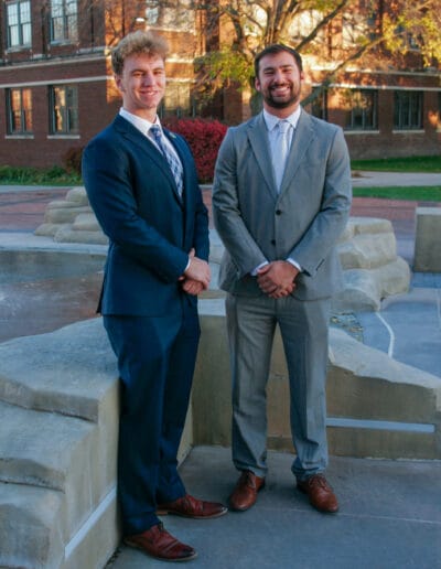 Sam Schroeder and Zane Grizzle pose by the water fountain on campus.
